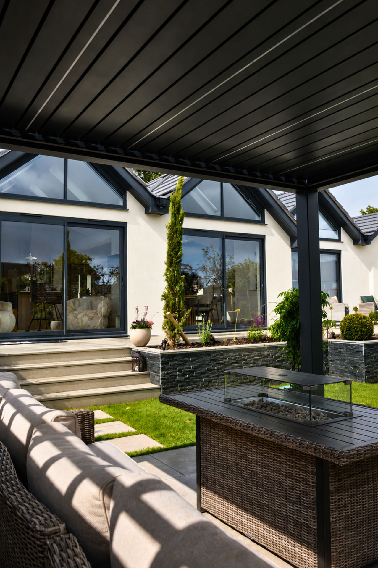 Freestanding Louv Pro pergola over patio seating and a fire pit